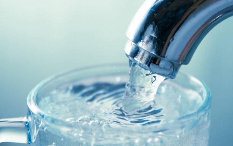 close-up view of water flowing from tap into glass